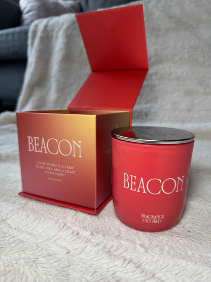 Fragrance to Fire Pink 'Beacon' candle in a matching box on a textured surface. Word is a lamp to my feet